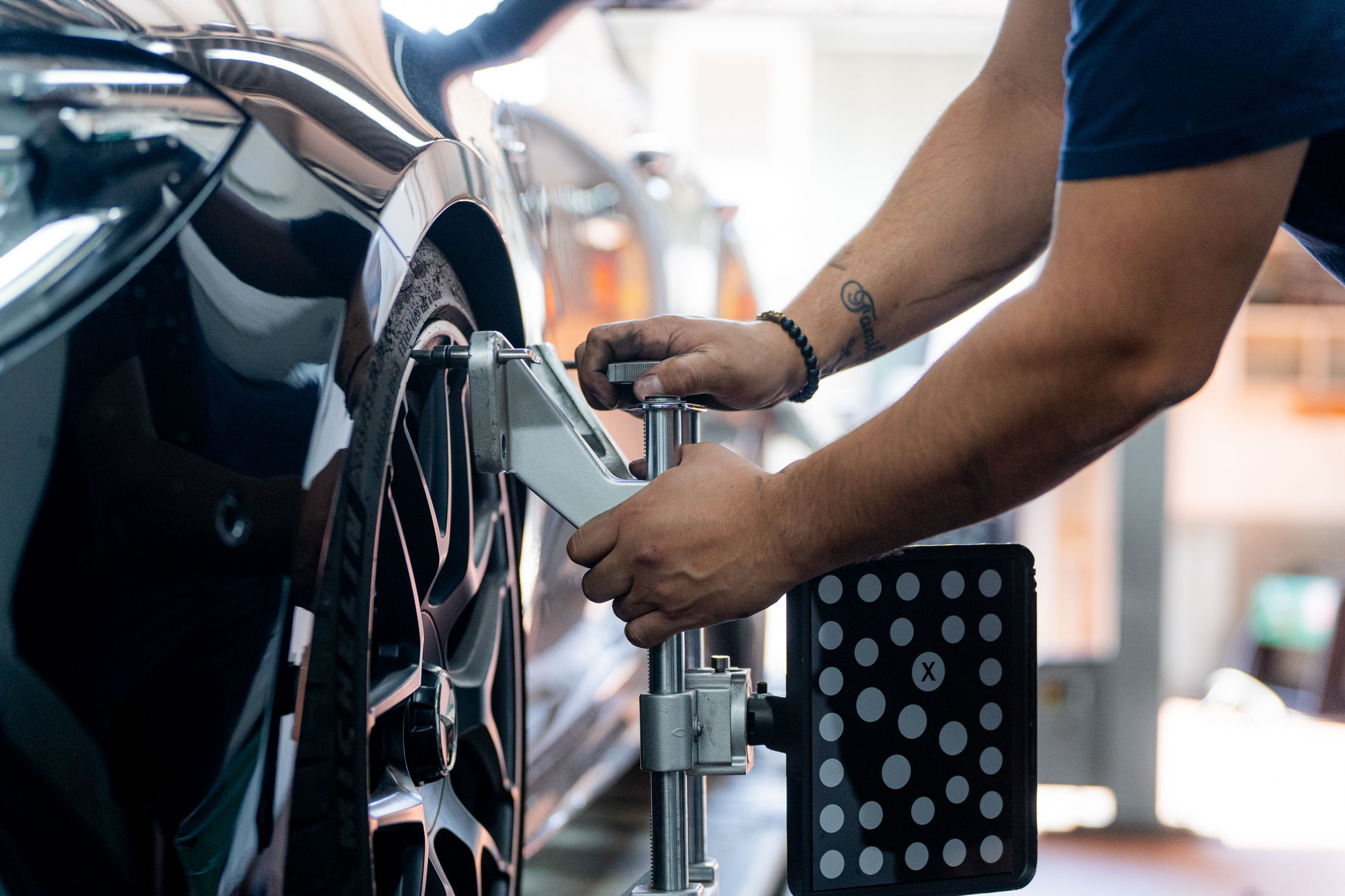 Ein Mann arbeitet an einem Autoreifen und führt Reparaturen oder Wartungsarbeiten durch.